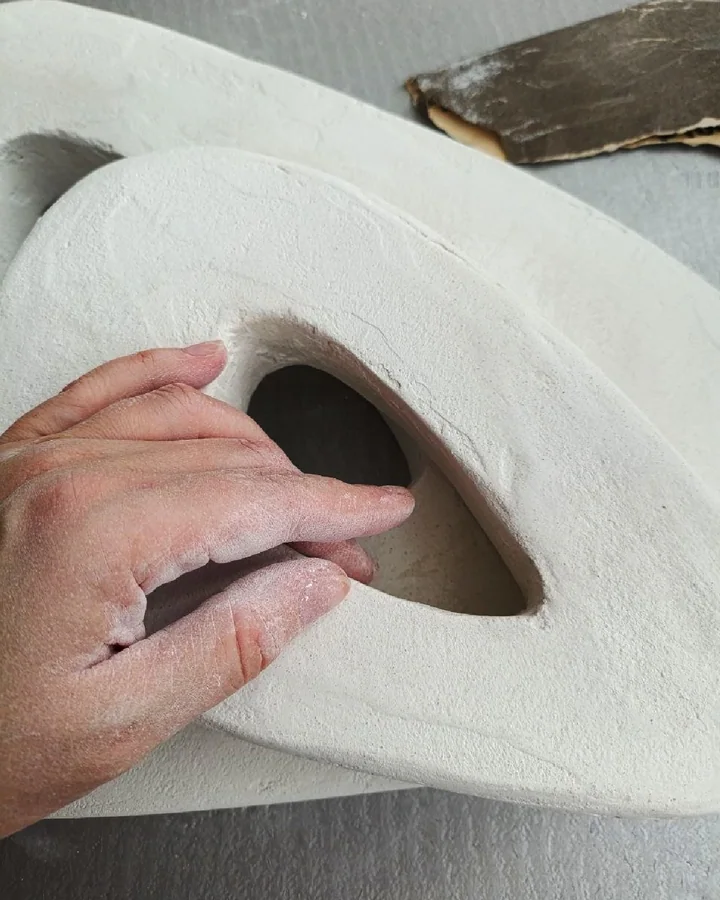 Kseniia’s hand sanding a cement sculpture before pigment